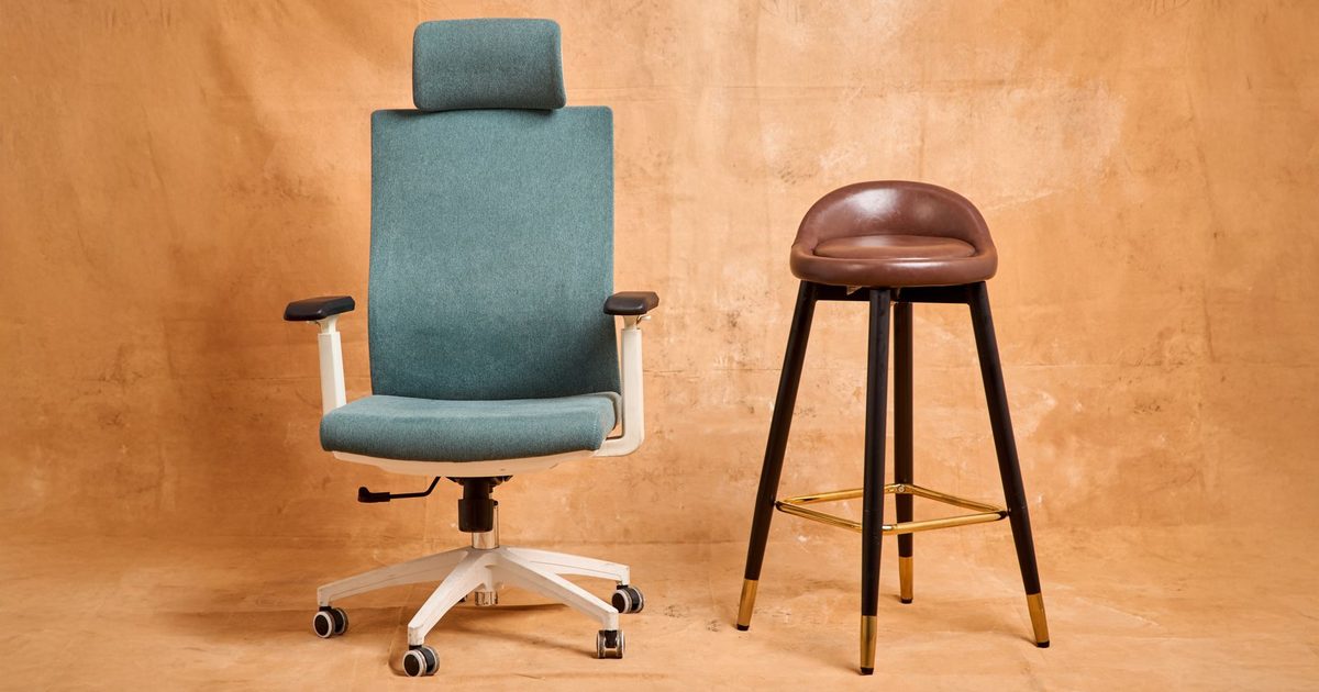 a high-back office chair with a headrest beside a tall stool