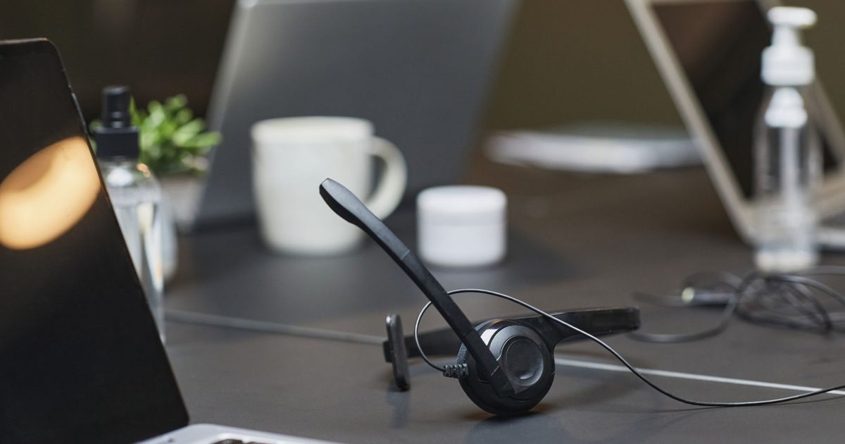 a headset with a boom microphone resting on a home office desk
