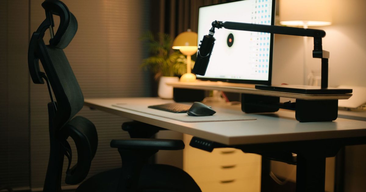 a monitor raised on a storage riser shelf on a home office desk